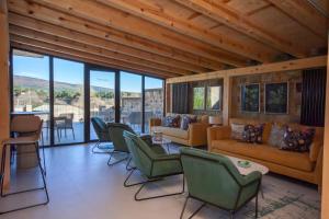 a living room with chairs and couches and windows at Duruelo Mountain Suites in Duruelo de la Sierra