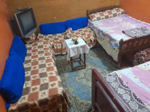 a room with two beds and a tv on a table at Elephantina sobek in Aswan