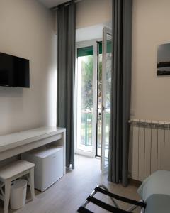 um quarto com uma cama, uma televisão e uma janela em Dimora Cavour em Nápoles