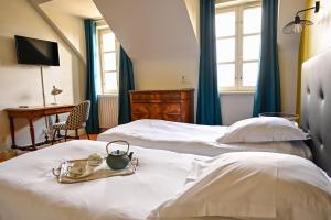 a bedroom with a bed with a tray with a tea kettle on it at Auberge Bretonne in La Roche-Bernard