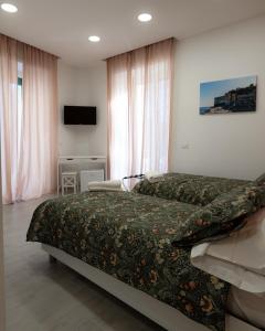 um quarto de hotel com duas camas e uma televisão em Dimora Cavour em Nápoles