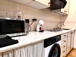 a kitchen counter with a microwave and a dishwasher at Apartamento Centrico con Parking in Rialp