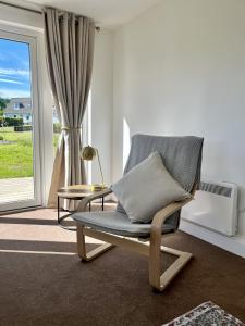 a rocking chair in a living room with a window at The Coorie in Bargrennan