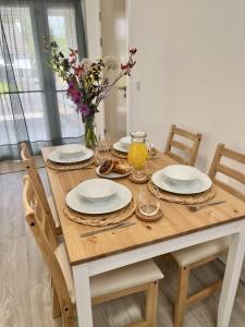 una mesa de madera con platos, vasos y flores. en The Coorie en Bargrennan