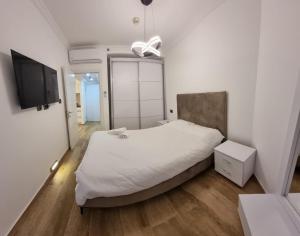 a bedroom with a bed and a flat screen tv at Kings Towers in Tiberias
