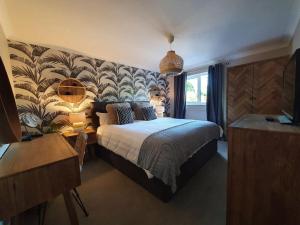 a bedroom with a large bed with a wall mural at Belle Vue Cottage in Downham Market