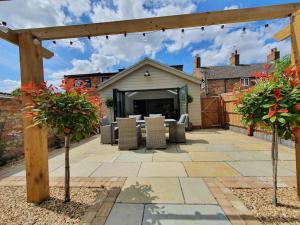 a patio with a table and chairs in a yard at Belle Vue Cottage in Downham Market