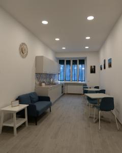 uma sala de estar com mesas e cadeiras e uma cozinha em Dimora Cavour em Nápoles