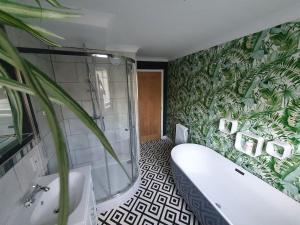 a bathroom with a tub and a green plant at Belle Vue Cottage in Downham Market +12 photos