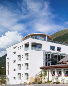 a white building with a dome on top of it at Hotel Station in Pontresina
