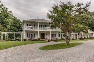 uma grande casa branca com uma árvore na entrada em Bonne Terre Inn Willow Room 