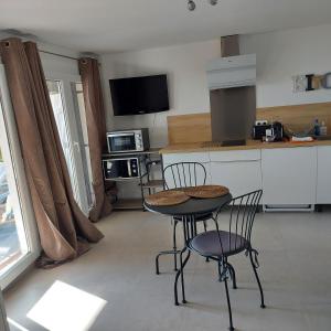 a kitchen with two chairs and a table in a kitchen at Appartement cosy vue mer in Magagnosc