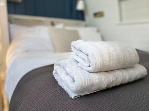 a pile of towels sitting on top of a bed at Sunset Cabin- glass frontage luxury couples cabin. in Shieldaig