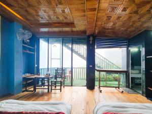 a room with a bed and a table and a balcony at Hoàng Hà Hotel Tam Đảo in Tam Ðảo