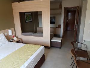 a hotel room with a bed and a mirror at Hot Springs B3 Apart in Caldas Novas