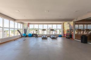 a large room with a gym with large windows at Tri Hotel Executive Brusque in Brusque