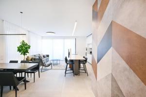 a living room with tables and chairs and a wall at Hotel comfort by HolyGuest in Tel Aviv