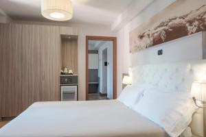 sypialnia z dużym białym łóżkiem w pokoju w obiekcie Hotel Garnì Cristallo w mieście Ponte di Legno +37 zdjęć