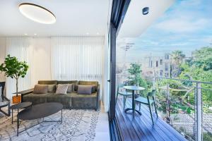 a living room with a couch and a balcony at Hotel comfort by HolyGuest in Tel Aviv
