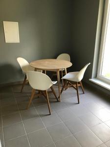 a wooden table and chairs in a room with a window at Klykių apartamentai in Inkartai