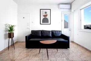 uma sala de estar com um sofá preto e uma mesa em Urban Condo 43 - 1 Bdr em Nicósia