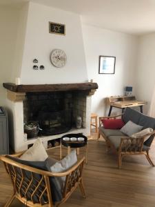 a living room with couches and a fireplace with a clock at Nice 120m with garden near the sea in Sainte-Marie-de-Ré