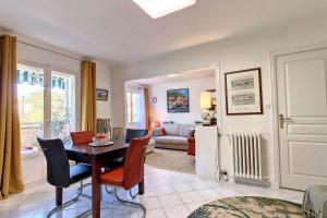 un soggiorno con tavolo e sedie di HENRI CAMILLE REAL ESTATE - ALEXANDRA - 2 bedrooms a Cannes