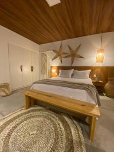 1 dormitorio con 1 cama grande y techo de madera en Pousada Corália, en São Miguel dos Milagres