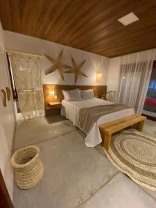 um quarto com uma cama grande e um tecto de madeira em Pousada Corália em São Miguel dos Milagres
