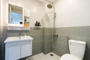 a bathroom with a shower and a toilet and a sink at Ekomo Home - Central Saigon in Ho Chi Minh City