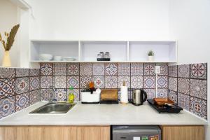 a kitchen with a sink and a tile wall at Ekomo Home - Central Saigon in Ho Chi Minh City