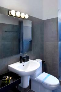 a bathroom with a sink and a toilet and a mirror at Urban Condo 43 - 1 Bdr in Nicosia