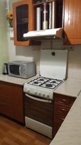 uma cozinha com um fogão e um micro-ondas em пр. Александра Поля 100, центральная часть города em Dnipro