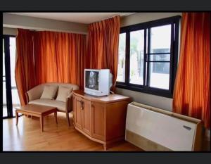 a living room with a couch and a tv on a cabinet at บ้านนาวาภิรมย์ ชะอํา in Ban Khlong Khot