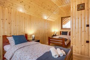 a bedroom with two beds in a wooden cabin at Apartment Stone and Wood in Cetingrad