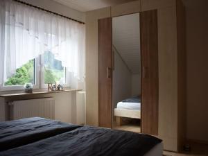 een slaapkamer met een bed en een raam bij Ferienwohnung Schwarzwaldblick in Bad Rippoldsau-Schapbach
