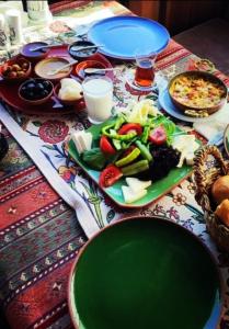 einen Tisch mit einem grünen Teller Essen drauf. in der Unterkunft Cave Art Hotel Cappadocia in Ürgüp