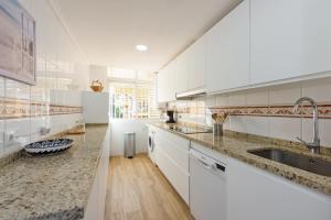 a large kitchen with white cabinets and a sink at Stay U-nique apartment Venezuela in Málaga