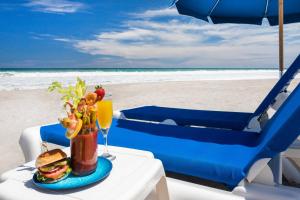 una mesa con un sándwich y una bebida en la playa en Crowne Plaza Melbourne-Oceanfront, an IHG Hotel, en Melbourne