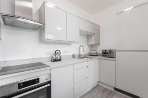 a white kitchen with white cabinets and stainless steel appliances at Platform City Theatre Studio with Secure Parking in Hull