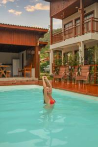 a woman laying in the water in a swimming pool at Pousada Rosa Maria in Praia do Rosa