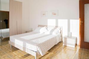 - une chambre blanche dotée d'un lit avec des draps et des oreillers blancs dans l'établissement 093 - Casa Panorama, Vista Mare e Vista Portofino, 500 metri centro di Chiavari, POSTO AUTO GRATIS INCLUSO, à Chiavari