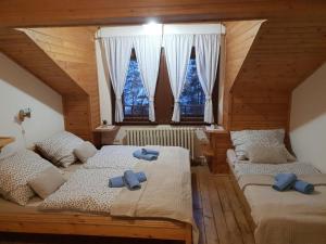 a bedroom with two beds with blue towels on them at Penzión Šafran in Stratená
