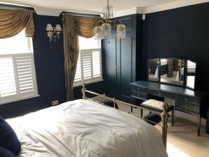 1 dormitorio con cama, escritorio y espejo en Luxury 2 bed Georgian Townhouse, Old Portsmouth en Portsmouth