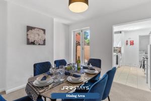 a dining room with a table and blue chairs at Nuneaton - Ideal 3 Bedroom, Wi-fi Parking, Sleeps 6 - JRR Stays in Stockingford