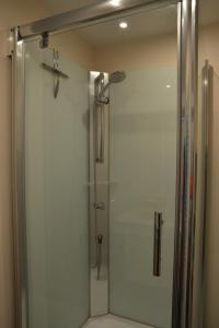 La salle de bains est pourvue d'une douche avec une porte en verre. dans l'établissement Bleus Nuit, à Lierneux