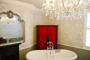 a bathroom with a red cabinet and a sink and a chandelier at Luxury 2 bed Georgian Townhouse, Old Portsmouth in Portsmouth