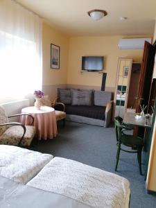 ein Wohnzimmer mit einem Sofa und einem Tisch in der Unterkunft Bianco in Sopron