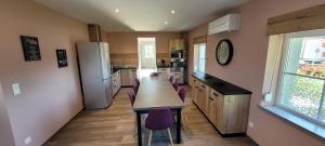 a kitchen with a long table and purple chairs at LA HALTE 19 in Ban-sur-Meurthe-Clefcy