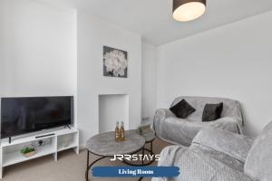 a living room with a couch and a tv at Nuneaton - Ideal 3 Bedroom, Wi-fi Parking, Sleeps 6 - JRR Stays in Stockingford